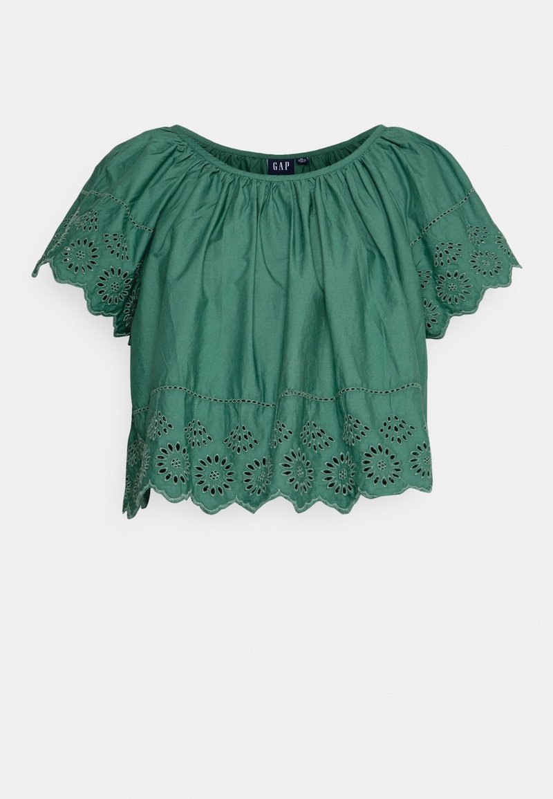 Blouse en coton vert avec manches courtes volantées et motifs ajourés brodés le long de l'ourlet et des manches. Encolure ronde et coupe décontractée.