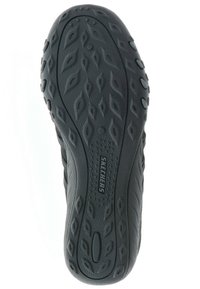 Skechers-sko yttersåle med en teksturert svart gummioverflate med et bladlignende mønster og en logo, designet for godt grep og holdbarhet.
