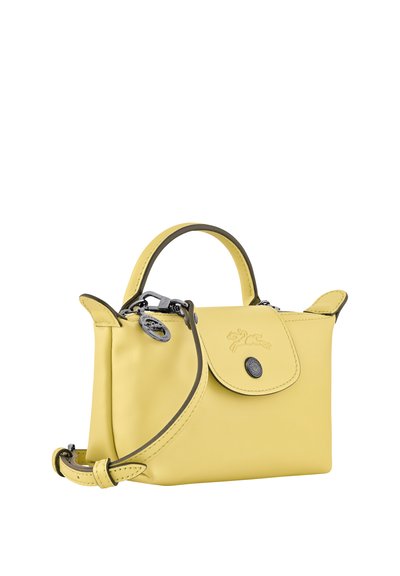 Small yellow leather handbag with top handle, front flap with button, and detachable shoulder strap, shown on white background.