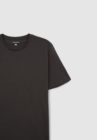 T-shirt nera a maniche corte realizzata in tessuto morbido. Collo a girocollo ribattuto. Etichetta con "Terranova XL" visibile. Design semplice e uniforme, senza motivi.