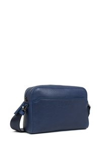 Borsa a tracolla in pelle blu navy con texture liscia, chiusura con zip, tracolla regolabile e logo impresso sul davanti.