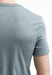 Gray short-sleeved t-shirt made of soft fabric, featuring a round neck and rolled sleeve cuffs, viewed from the back.