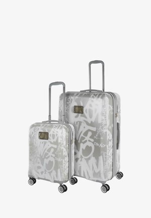 Dos maletas rígidas con patrones de graffiti, color gris, asas extensibles, ruedas giratorias y una placa de logo metálica en la parte frontal.