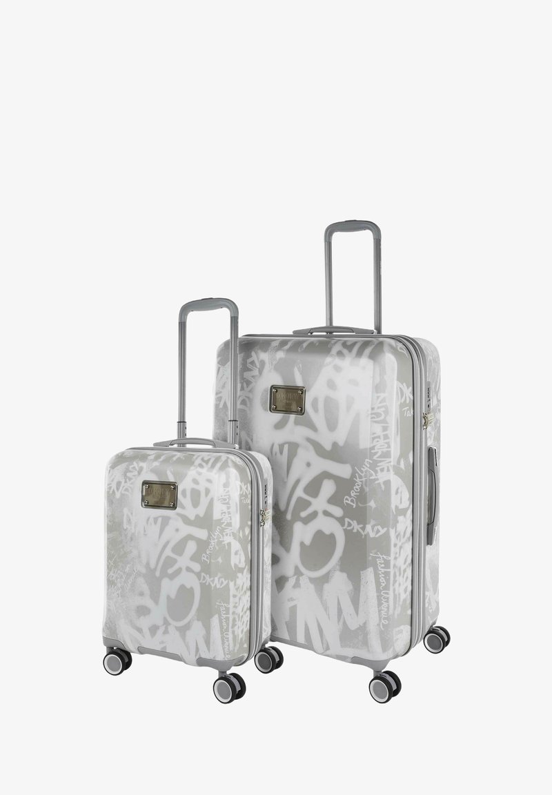 Dos maletas rígidas con patrones de graffiti, color gris, asas extensibles, ruedas giratorias y una placa de logo metálica en la parte frontal.