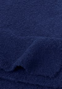 Mørkeblå stof med en tekstureret, fluffy overflade, der viser en let drapering og et blødt, luksuriøst udseende. Ingen synlige mønstre eller hardware.