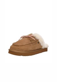 Teddybruin slip-on pantoffels van lichtbruin suede met een bontomslag, een roze strikaccent en een gestructureerde rubberen zool. Voorzien van gedetailleerde stiksels langs de rand.