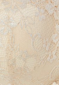 Nude spetsmaterial med blommönster, texturerade detaljer och en subtil skimrande effekt. Tyget är fint och genomskinligt.