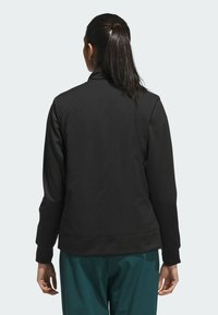 Black zip-up jacket with a fitted design, ribbed cuffs, and hem. Smooth texture, with a clean silhouette and no visible logos or accents.