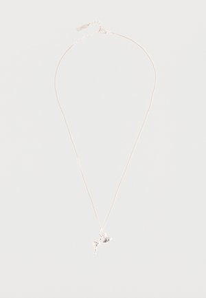 Collana con catena d'argento e un piccolo ciondolo a forma di fata con ali e posa seduta su uno sfondo semplice.