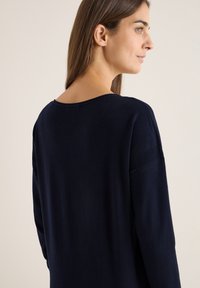 Pullover blu navy con scollo rotondo, maniche lunghe e dettagli testurizzati sulle spalle. Tessuto morbido a maglia con vestibilità comoda.