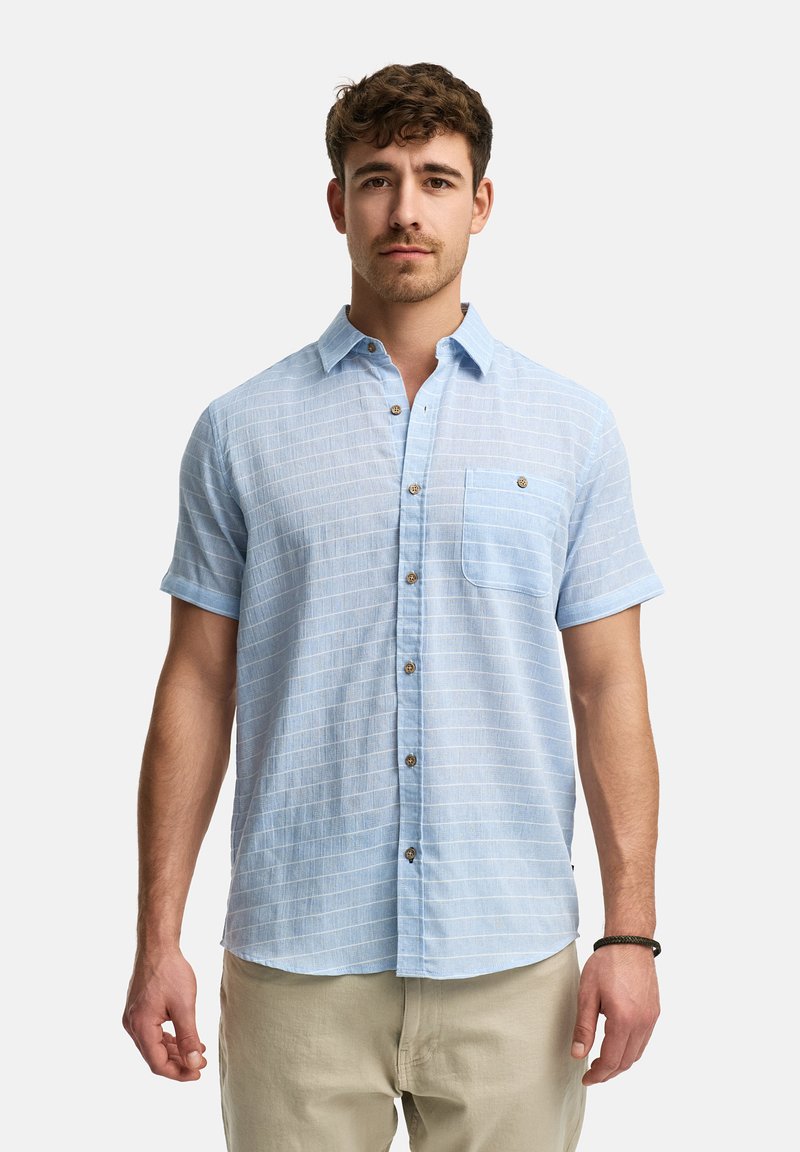 Camisa de manga corta de color azul claro con un patrón texturizado y cierre de botones. Presenta un solo bolsillo en el pecho y un sutil detalle de rayas.