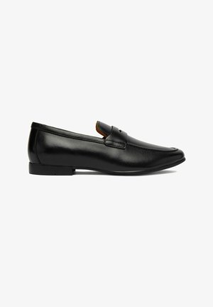 Czarny skórzany męski mokasyn typu slip-on z niskim obcasem i paskiem na cholewce, pokazany z profilu na białym tle.