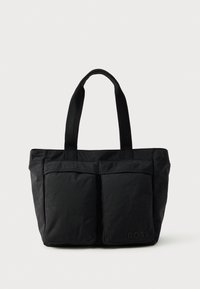 Sac fourre-tout noir en tissu doux, avec deux poches avant et des anses robustes. Logo affiché sur le côté. Design simple et fonctionnel.