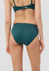 Türkisfarbene nahtlose Bikiniunterteile mit glatter Textur, breitem Bund und dezentem Logo auf der Rückseite.