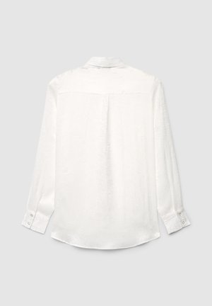 Camicia bianca a maniche lunghe con bottoni, colletto, motivo sottile a rilievo e polsini con bottoni, vista da dietro su uno sfondo chiaro.