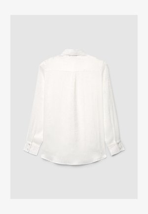 Camicia bianca a maniche lunghe con bottoni, colletto, motivo sottile a rilievo e polsini con bottoni, vista da dietro su uno sfondo chiaro.