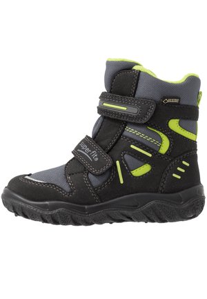 Schwarze und graue Winterstiefel mit strukturiertem Finish, ausgestattet mit neon-grünen Akzenten, verstellbaren Riemen und einer robusten Sohle für gute Traktion.