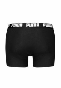 Boxer neri realizzati in un materiale morbido, con un ampio elastico in vita che presenta il logo "PUMA" bianco sulla parte superiore.