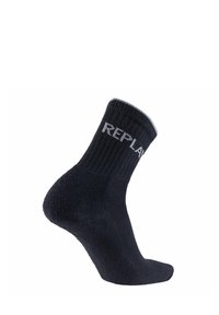 Chaussette en coton noire avec une texture côtelée et un revers gris contrastant. Logo "REPLAY" en blanc sur le côté, design montant jusqu'à la cheville.