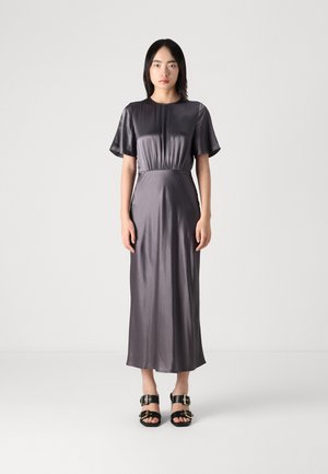 Long, dark gray satin dress with short sleeves and elastic waist, complemented by black sandals with gold hardware accents. Smooth texture.