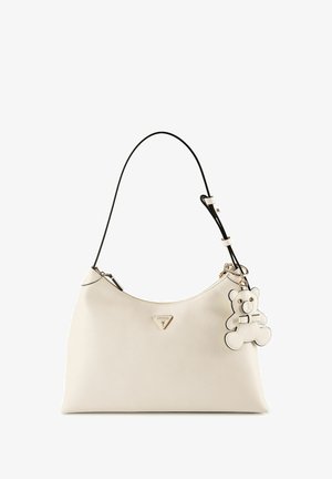 Sac à main en cuir crème avec bandoulière noire, logo Guess triangulaire et porte-clés peluche crème attaché.