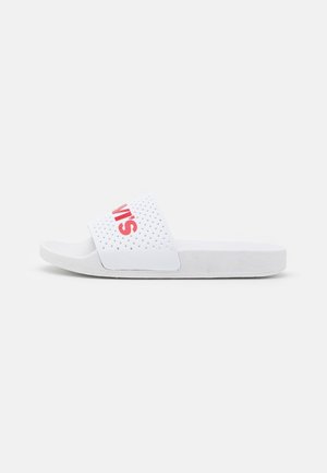 Sandale blanche à enfiler avec une bride perforée et un logo partiel rouge "LEVIS" sur fond blanc.