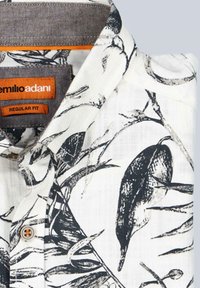 Weißes Hemd mit schwarzgrünem Blattdruck, ausgestattet mit einem normalen Kragen, dunkelgrauem Innenfutter und einem Knopfdetail mit orangefarbenem Akzent.