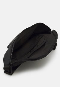 Borsa in tessuto nero, forma rettangolare, con chiusura a zip. Interno liscio con tasca laterale, tutto in un design totalmente nero.