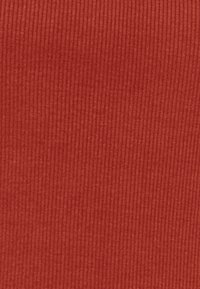 Tessuto a coste di un caldo tono rosso, con una texture fine e linee verticali, che creano un aspetto morbido e strutturato.