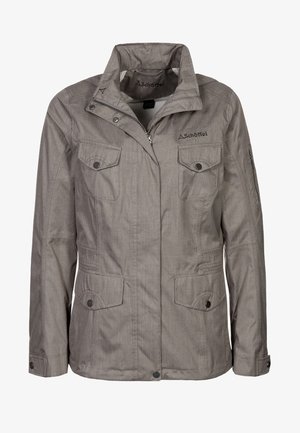 Harmaa pehmeäkuorinen takki, jossa on kauluksellinen kaula, etuvetoketju, kaksi suurta rintataskua ja sivutaskut; takissa on hienovarainen tekstuuri ja brändäys.