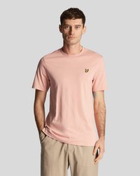T-shirt en coton rose clair à manches courtes, col rond, avec un petit logo de papillon noir et jaune sur la poitrine gauche.