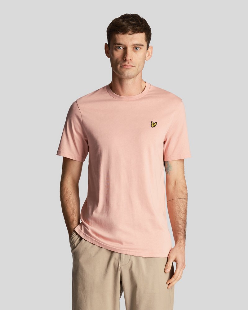 T-shirt en coton rose clair à manches courtes, col rond, avec un petit logo de papillon noir et jaune sur la poitrine gauche.