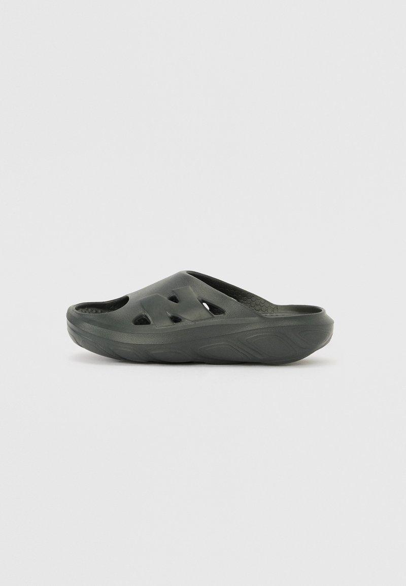 Sabot en caoutchouc vert foncé, avec des trous de ventilation découpés et une semelle intérieure texturée pour plus de confort.