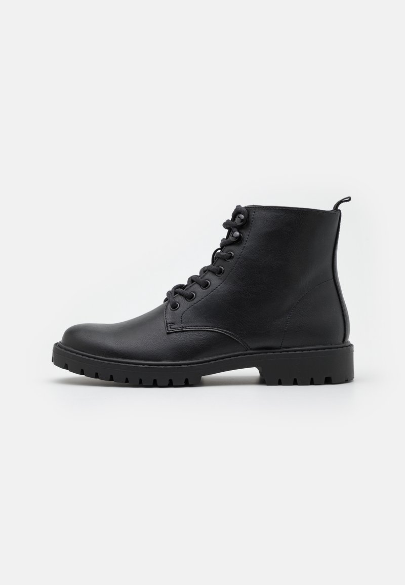 Botas de cuero negras hasta el tobillo con punta redondeada, cordones en la parte delantera, superficie texturizada y suela de goma resistente con profundos surcos para mayor tracción.