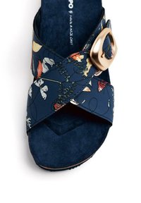 Sandale à glissière florale bleu marine avec des bretelles croisées en matériau lisse, dotée d'une boucle dorée et d'une semelle intérieure douce et texturée.