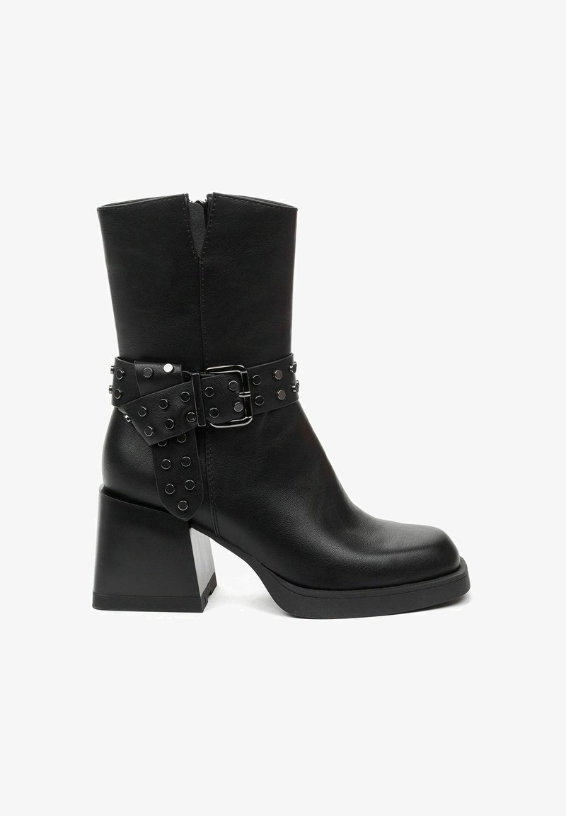 Black leather ankle boot featuring a chunky block heel, zip closure, and a decorative buckle strap with stud accents around the ankle.
