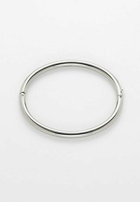 Bracciale metallico d'argento, forma circolare con una superficie liscia e lucida. Presenta un leggero giunto per aprire e chiudere. Design semplice.