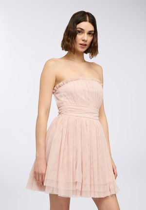 Abito senza spalline di un delicato rosa pastello, realizzato in tulle stratificato con un colletto arricciato e una cintura arricciata. Presenta una gonna svasata con pieghe.