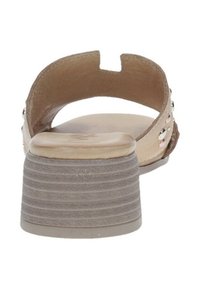 Sandalo beige con punta arrotondata, retro aperto e tacco a blocco grigio svasato. Dotato di borchie decorative in accenti di argento e rosa.