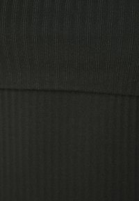 Tessuto nero a righe verticali con una texture liscia, caratterizzato da due sezioni distinte con motivi di costina variabili.