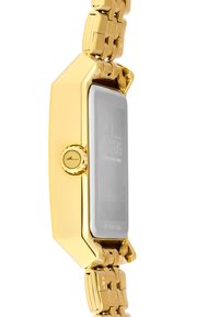 Reloj de metal dorado con una esfera rectangular plateada, correa texturizada y una corona redonda en el lateral. Logo grabado y detalles del modelo visibles.