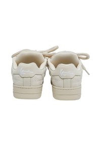 Beżowe sneakersy z pikowaną teksturą, okrągłym noskiem i płaską gumową podeszwą. Miękka podszewka z tkaniny oraz logo na pięcie. Sznurowadła w dopasowanym kolorze.