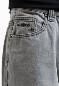 Gray washed denim shorts with a slight texture, featuring black stitching and "WASHED" embroidered on the back pocket.