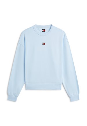 Sweat-shirt bleu clair à manches longues avec col rond, poignets et bas côtelés, avec un petit logo Tommy Jeans sur la poitrine et une étiquette au niveau du col.