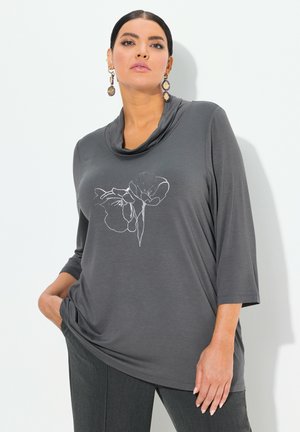 Top grigio con collo a cowl e maniche a tre quarti, caratterizzato da un design floreale ricamato in bianco. Realizzato in un tessuto morbido e elasticizzato.
