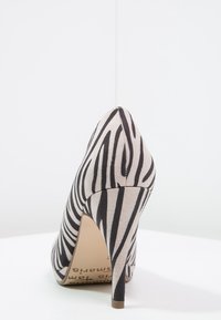 Dámská vysoká obuv s špičatou špičkou, potažená béžovou látkou s černými zebra pruhy. Disponuje štíhlým stiletto podpatkem a hladkým povrchem.
