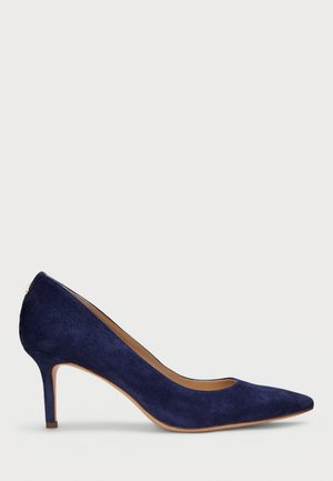 Chaussure à talon haut en daim bleu marine avec bout pointu, talon fin de hauteur moyenne et semelle beige, vue de profil droit sur fond blanc.