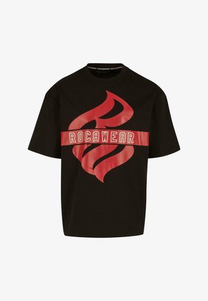 Must mustriga lühikeste varrukatega särk, millel on suur punane leekgraafika ja "ROCAWEAR" tekst horisontaalsel punasel ribal rinna kohal.