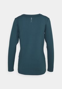 Langärmliges, türkisfarbenes Oberteil aus weichem Stoff mit rundem Halsausschnitt und kleinem Logo auf dem Rücken. Glatte Textur und taillierte Passform.