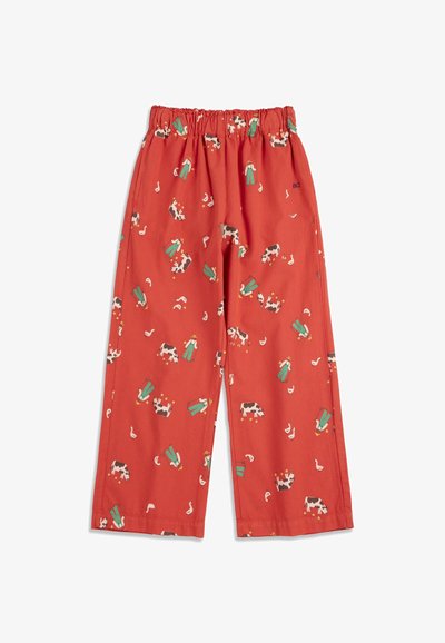 Pantalon rouge pour enfants avec une taille élastique, présentant un motif sur le thème de la ferme avec des vaches, des fermiers et des canards blancs.